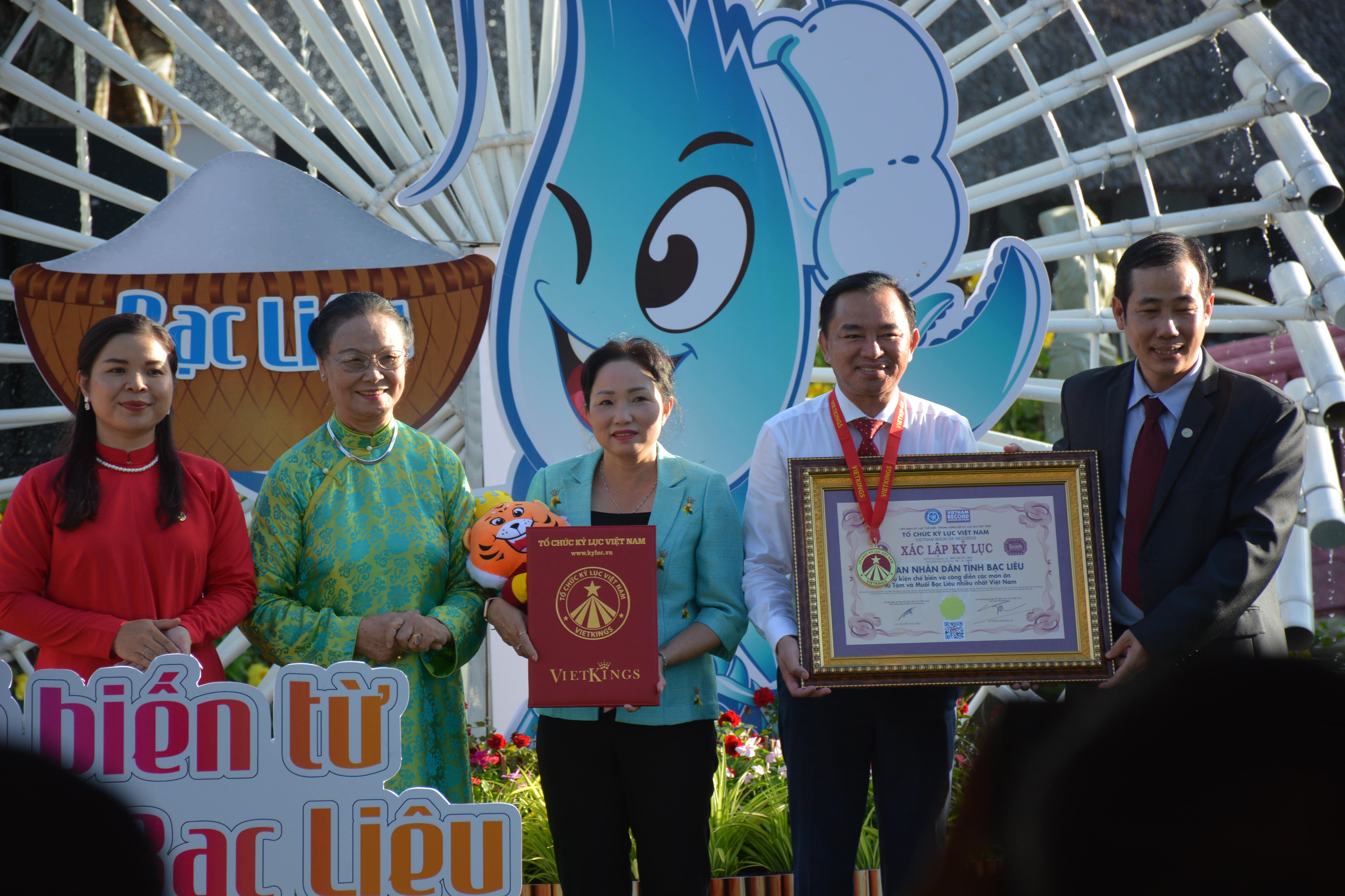 Phó Chủ tịch UBND tỉnh Bạc Liêu Phan Thanh Duy (áo trắng) nhận Bằng chứng nhận xác lập kỷ lục Việt Nam của VietKings về sự kiện chế biến và công diễn 122 món ăn từ tôm và muối Bạc Liêu nhiều nhất Việt Nam. Ảnh Trần Lợi